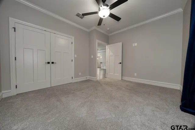 a view of an empty room with a ceiling fan