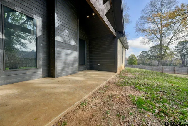 a view of backyard with large trees and plants