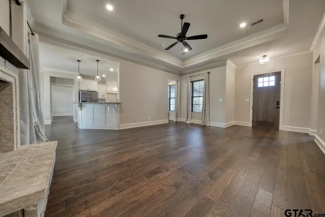 a view of empty room with wooden floor and ceiling fan