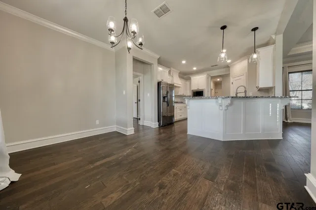 a view of a kitchen with cabinets and wooden floor