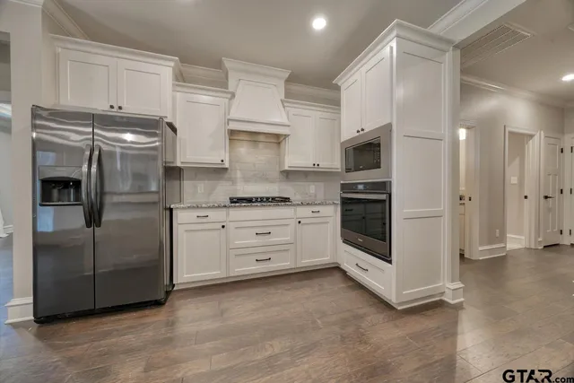 a kitchen with stainless steel appliances a refrigerator and a stove top oven