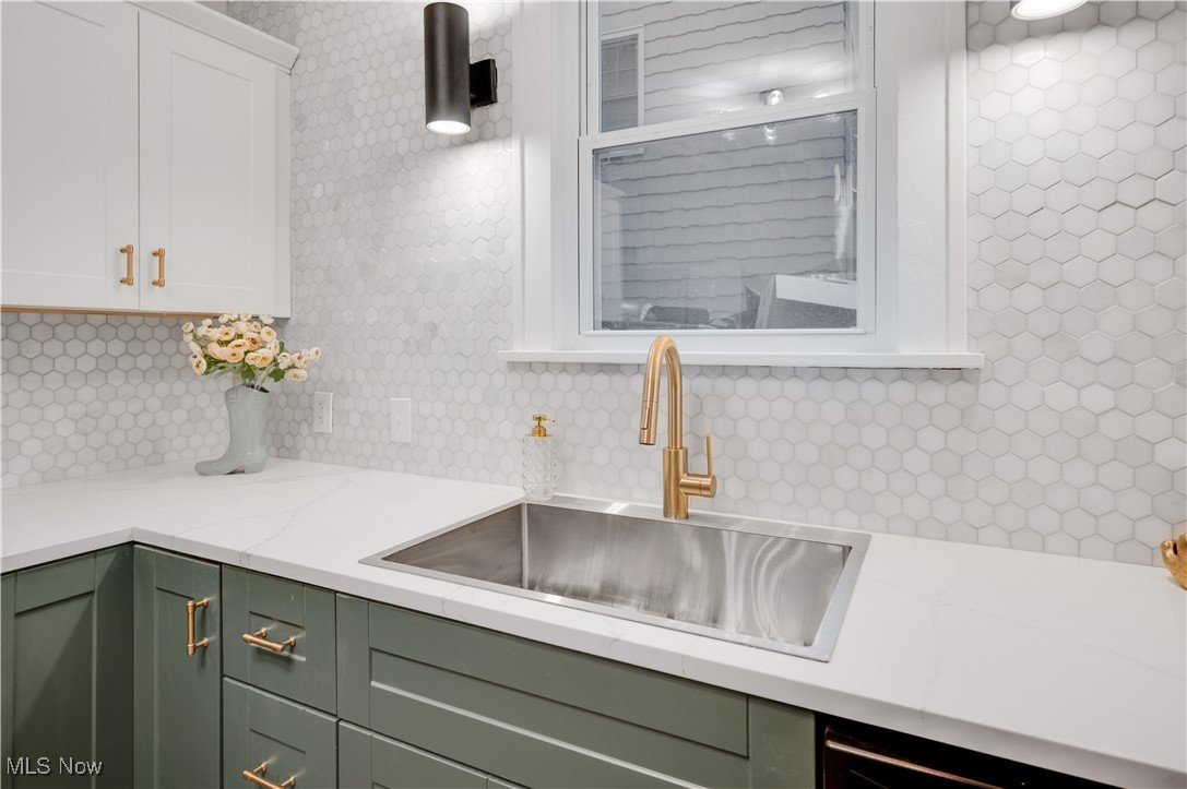2016 Rossmoor Road Cleveland Heights, OH 44118 - Photo 20 of 46 Kitchen with green cabinets, decorative backsplash, white cabinetry, and light stone counters