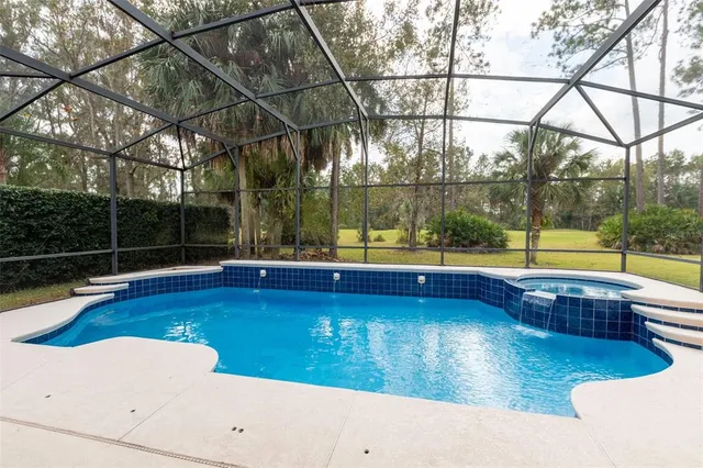 a view of a swimming pool with a patio and a yard