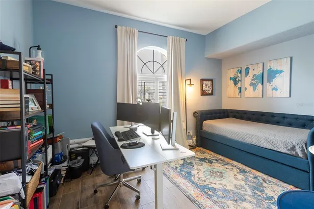 a bedroom that has a bed and a desk in it