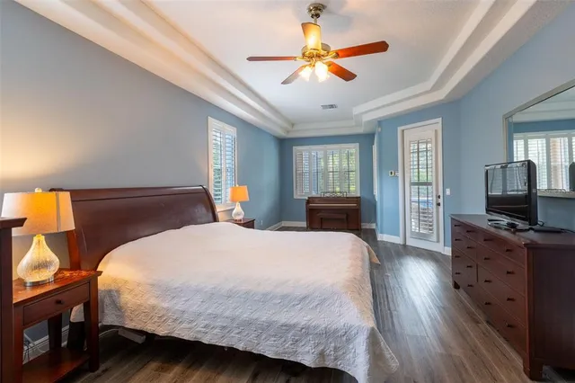 a bedroom with a bed a flat screen tv and dresser