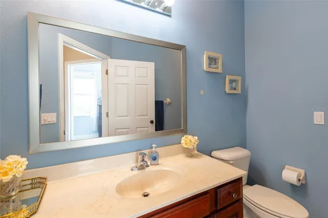 a bathroom with a sink vanity mirror and toilet