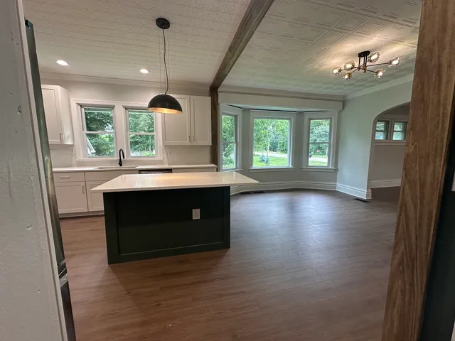 a kitchen with kitchen island a sink wooden floor and a fireplace