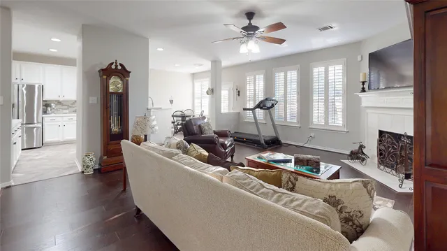 a living room with furniture kitchen view and a chandelier