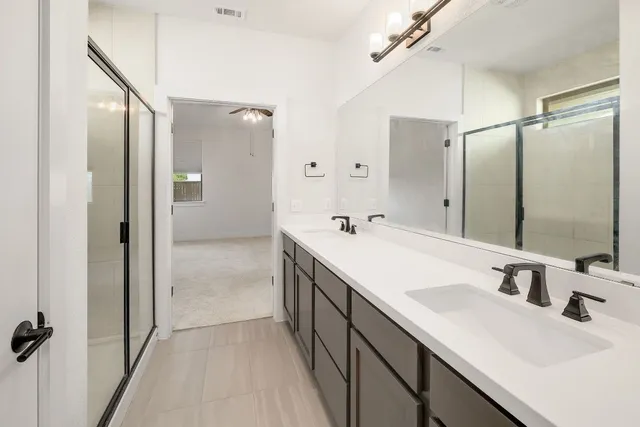 a bathroom with a double vanity sink a mirror and shower