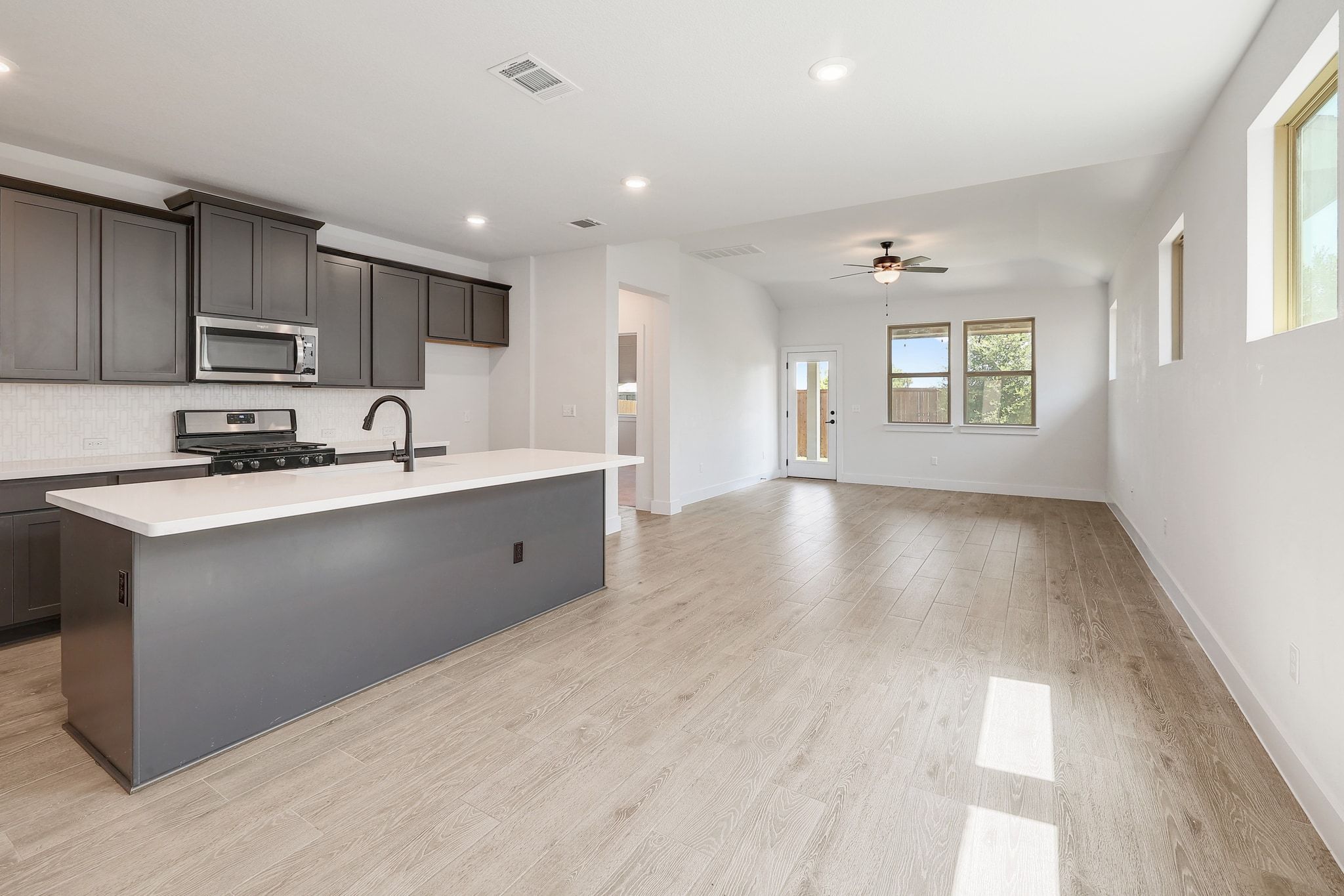 6111 Dunfries Lane Austin, TX 78744 - Photo 7 of 30 a kitchen with kitchen island granite countertop a sink window and cabinets