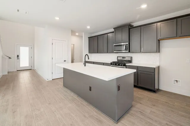 a kitchen with a sink cabinets and wooden floor