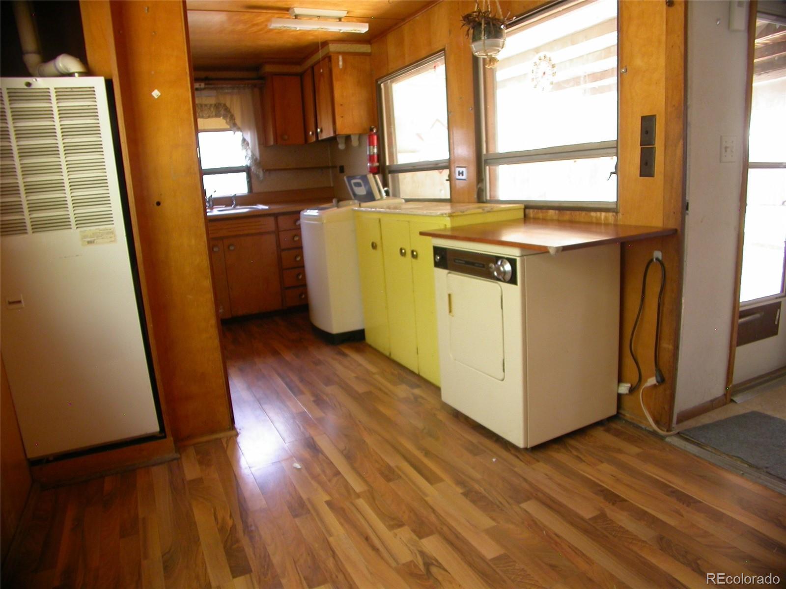 a view of a kitchen with wooden floor and a sink