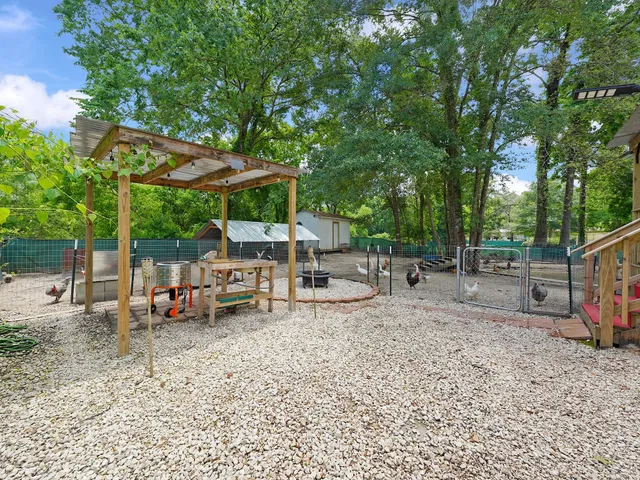 a backyard of a house with wooden fence and large trees