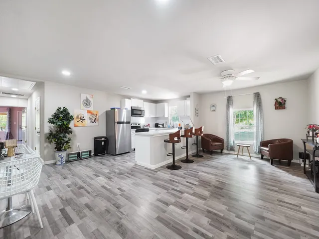 a kitchen with white cabinets and refrigerator