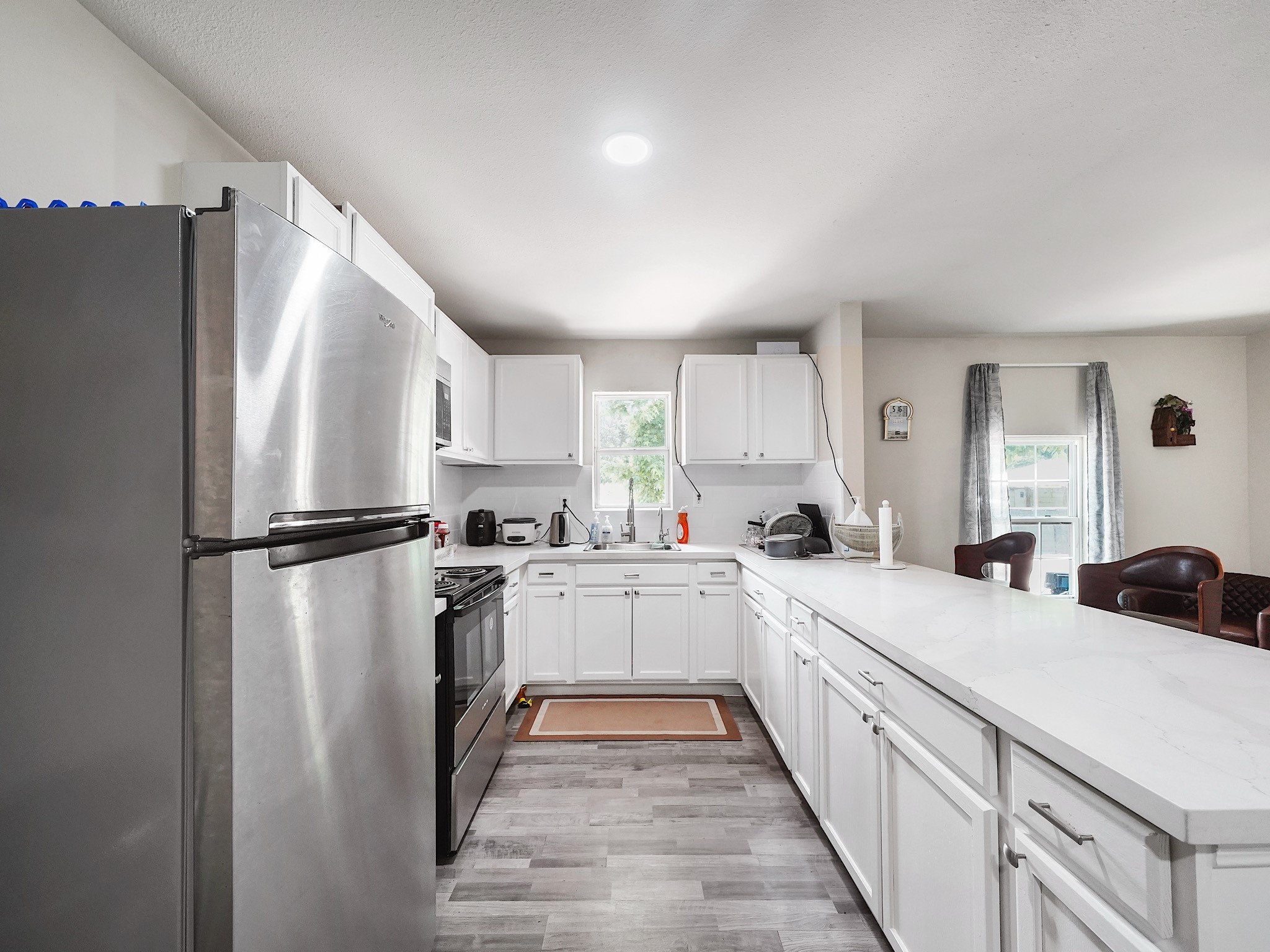 29 County Road 2131, Unit A Cleveland, TX 77327 - Photo 8 of 24 a kitchen with white cabinets and refrigerator