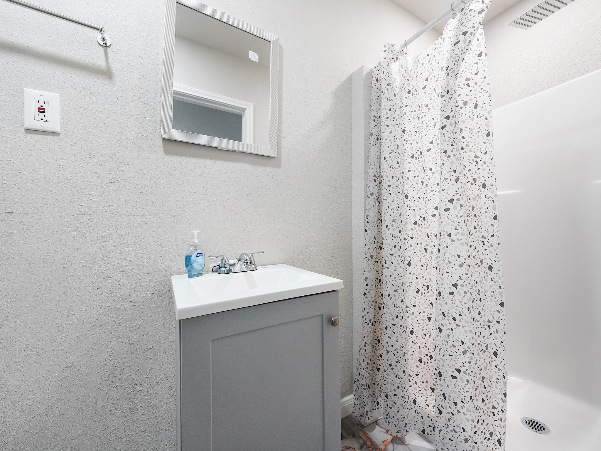29 County Road 2131, Unit A Cleveland, TX 77327 - Photo 10 of 24 a bathroom with a sink a mirror and shower curtain