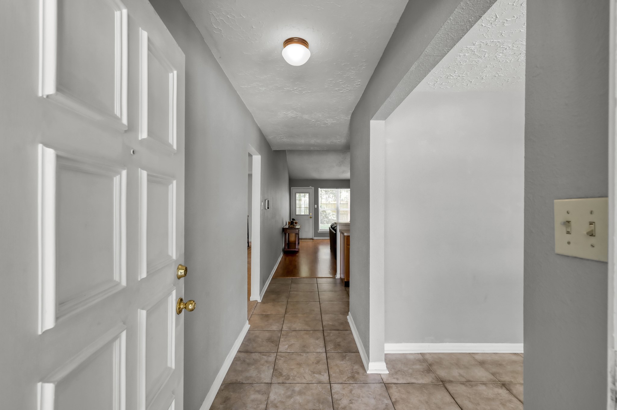 4314 Enchantedgate Drive Spring, TX 77373 - Photo 4 of 47 Welcoming entryway with neutral gray walls and tile flooring. The hallway leads to a bright dining area with natural light from the windows, creating an inviting first impression.