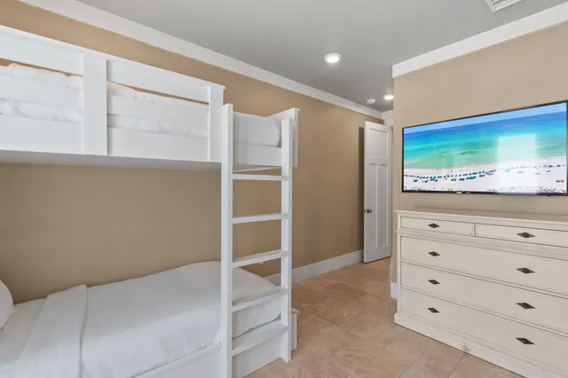 a bedroom with a large bed and a flat tv screen on dresser
