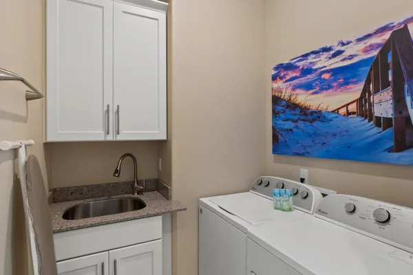 a bathroom with a granite countertop double vanity sink mirror and shower