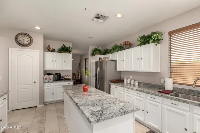 a kitchen with granite countertop a sink a stove and cabinets