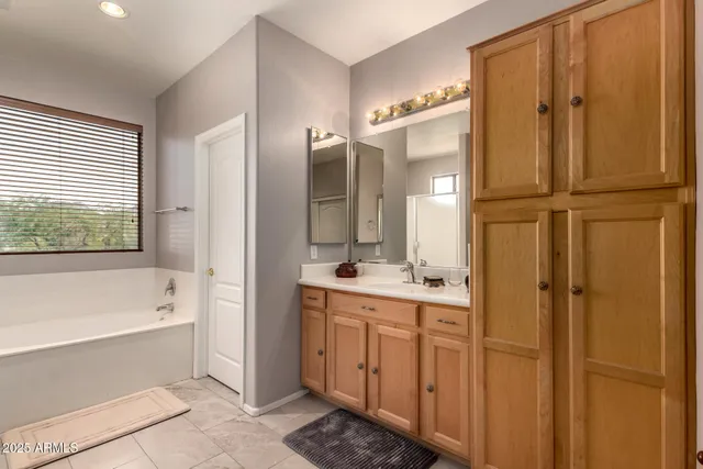 a bathroom with a tub a sink and mirrors