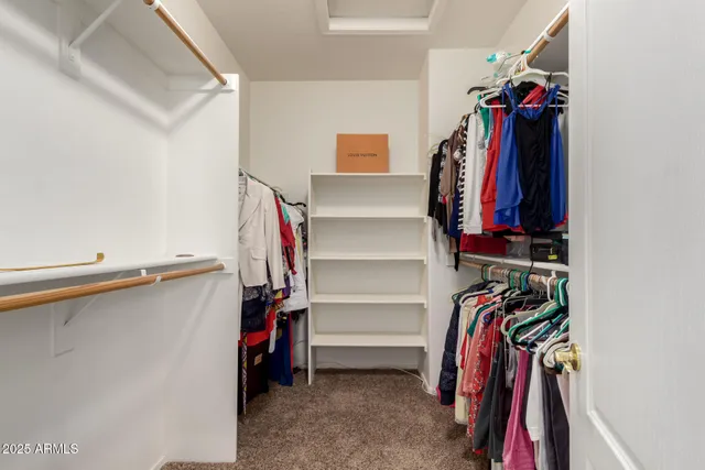 a view of walk in closet with clothes and shoes