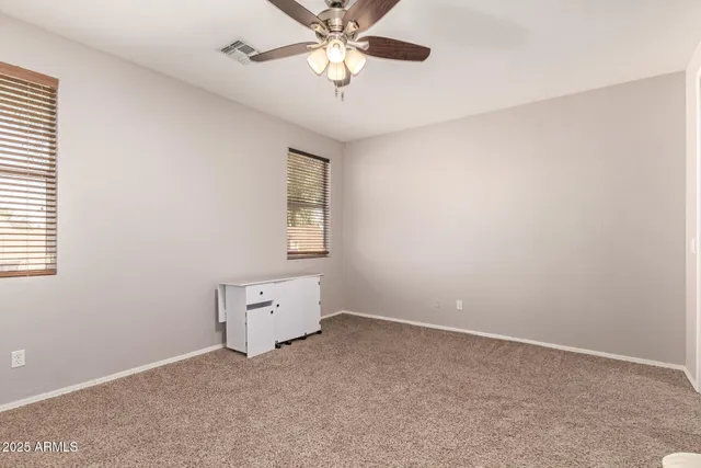 an empty room with a window and a fan