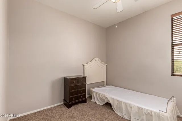 a bedroom with a bed and a chandelier fan