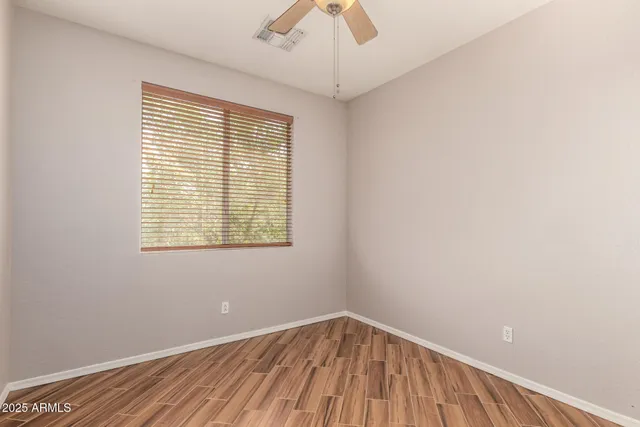 an empty room with a window and wooden floor
