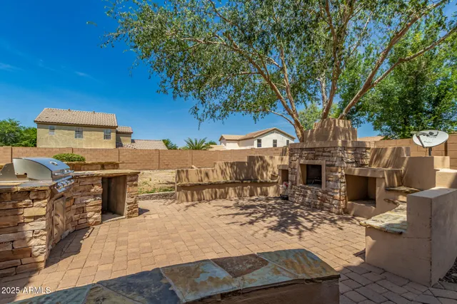 a view of a patio with wooden table and chairs