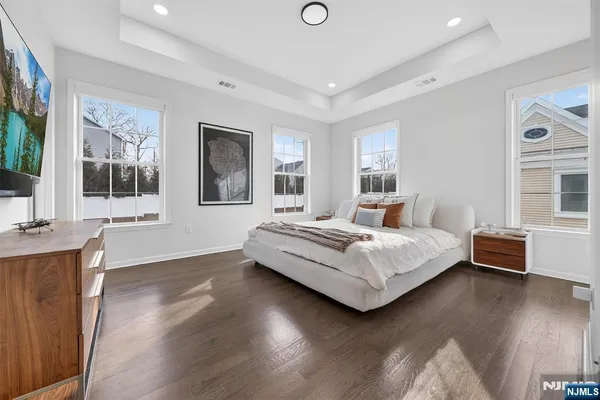 a bedroom with a large bed and wooden floor