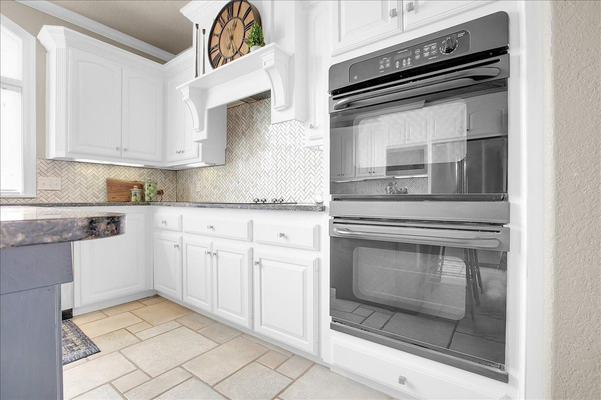 4818 104th Street Lubbock, TX 79424 - Photo 14 of 36 a kitchen with granite countertop white cabinets stainless steel appliances and sink