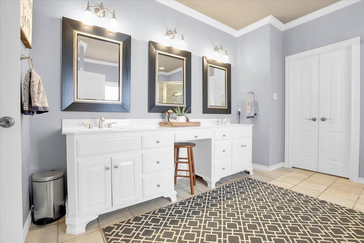 4818 104th Street Lubbock, TX 79424 - Photo 20 of 36 a bathroom with a sink a toilet and a mirror