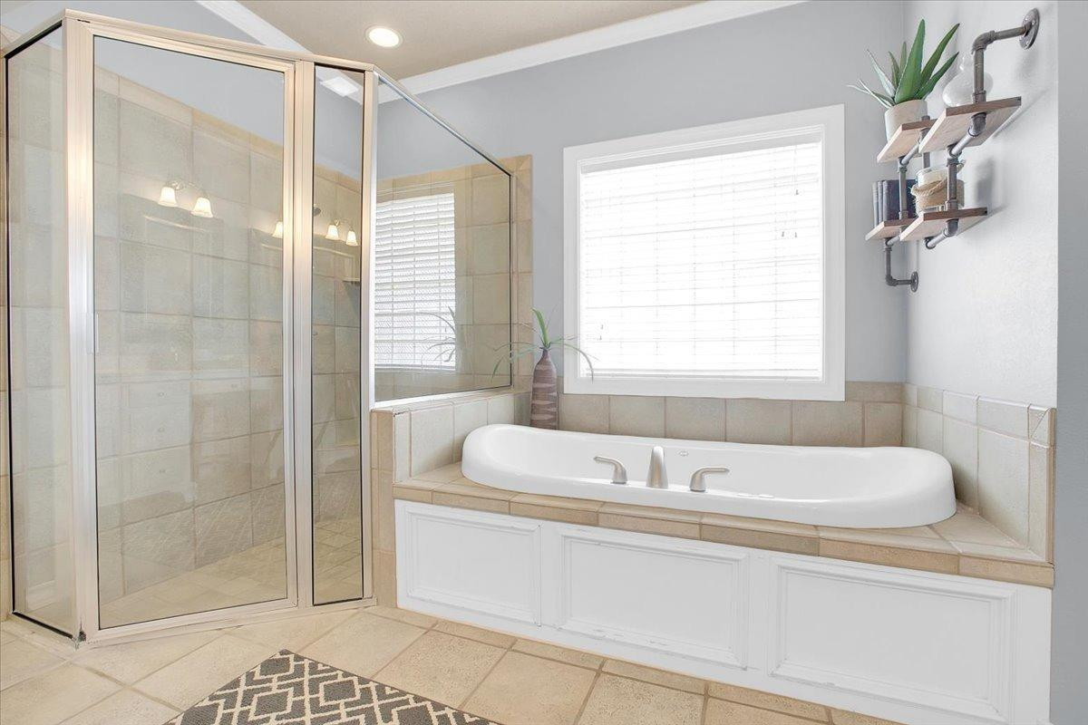 4818 104th Street Lubbock, TX 79424 - Photo 21 of 36 a bathroom with a bathtub and a shower