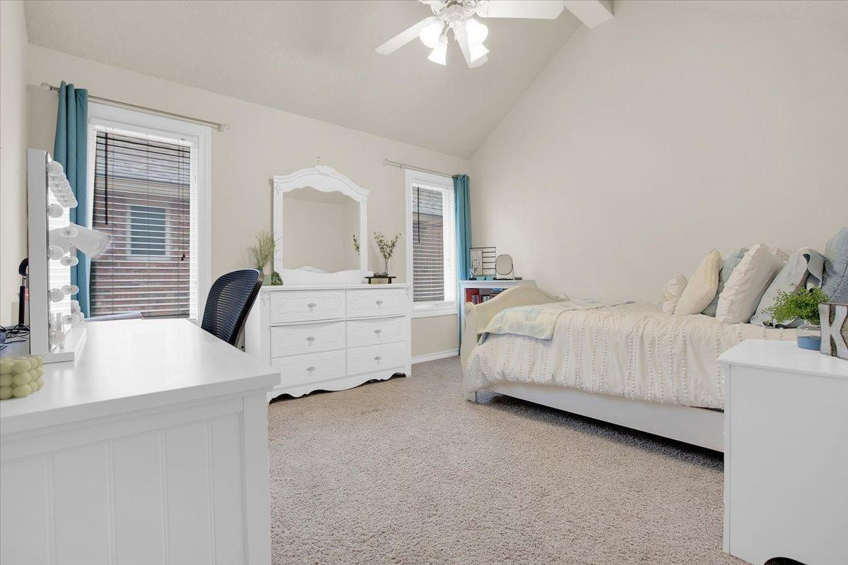 4818 104th Street Lubbock, TX 79424 - Photo 26 of 36 a bedroom with a bed and a chandelier