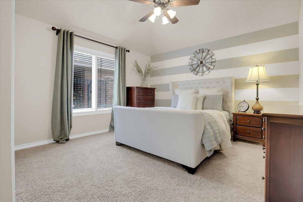 4818 104th Street Lubbock, TX 79424 - Photo 29 of 36 a bed room with a bed and a chandelier