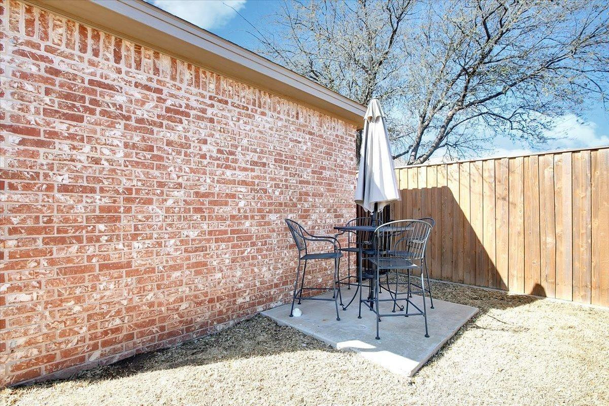 4818 104th Street Lubbock, TX 79424 - Photo 35 of 36 a view of a patio with table and chairs with wooden floor and fence