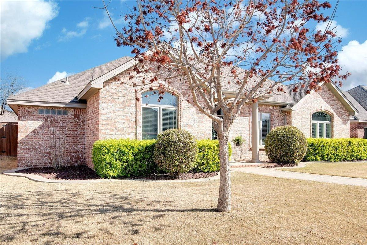4818 104th Street Lubbock, TX 79424 - Photo 4 of 36 a front view of a house with a yard and potted plants