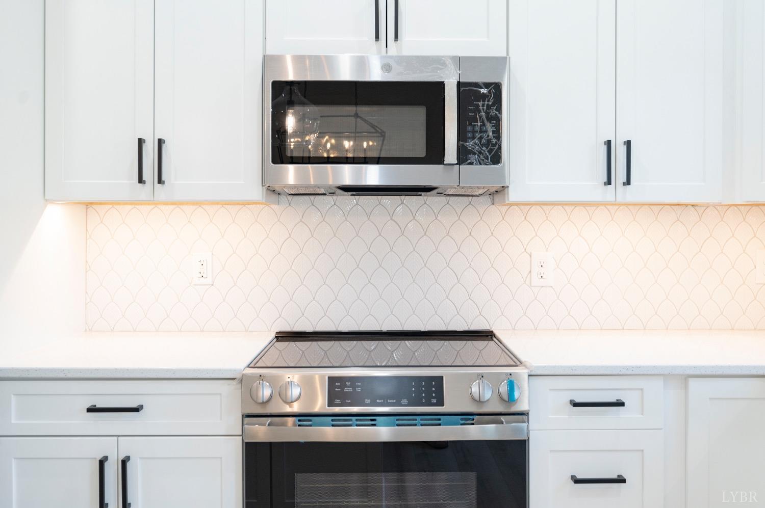 2329 Perrowville Road Forest, VA 24551 - Photo 20 of 54 Spacious kitchen with custom cabinets, tile backsplash, oversized island, stainless appliances and quartz countertops.