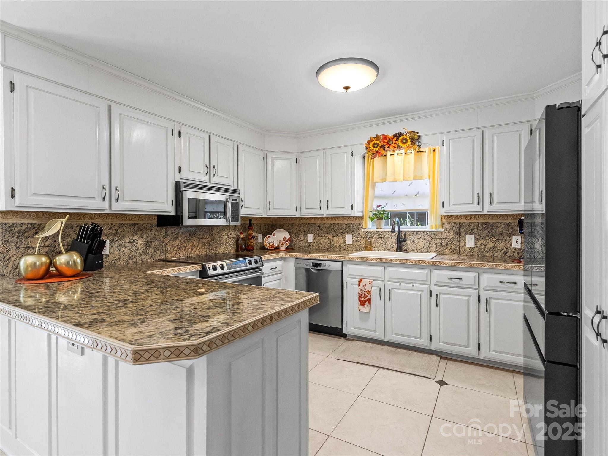 1002 4th Street Northeast Conover, NC 28613 - Photo 10 of 47 a kitchen with kitchen island granite countertop a stove sink and cabinets