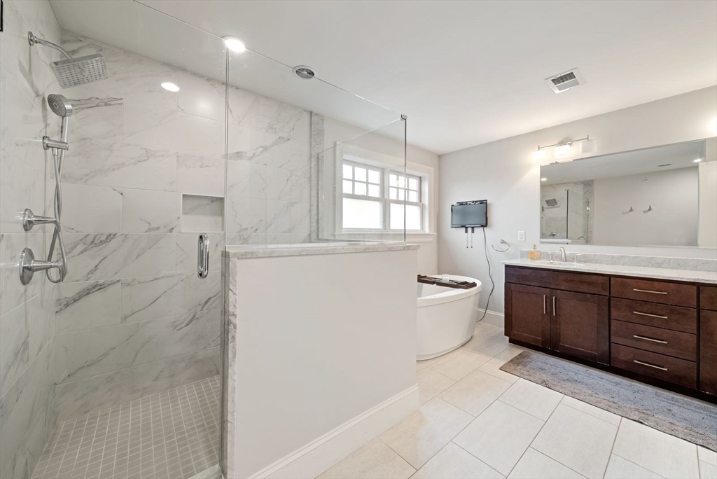21 Lillian Way, Unit 21 Wayland, MA 01778 - Photo 21 of 33 a large bathroom with a double vanity sink toilet mirror and shower