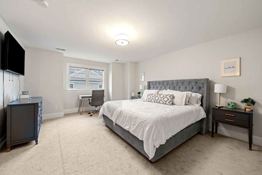 21 Lillian Way, Unit 21 Wayland, MA 01778 - Photo 23 of 33 a bedroom with a bed and a flat screen tv