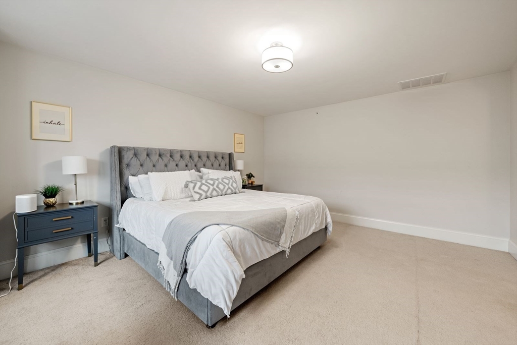 21 Lillian Way, Unit 21 Wayland, MA 01778 - Photo 24 of 33 a bedroom with a bed and chair