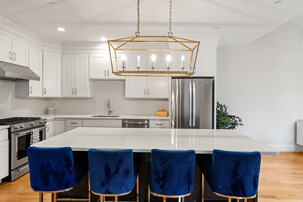 21 Lillian Way, Unit 21 Wayland, MA 01778 - Photo 3 of 33 a kitchen with a table chairs stove and cabinets