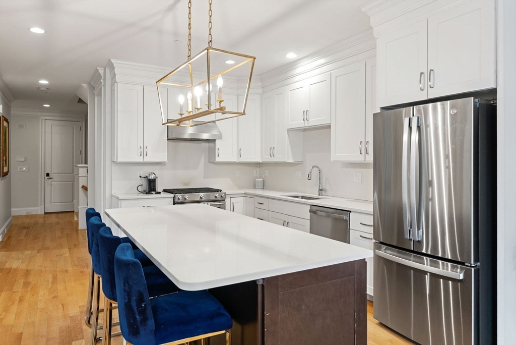 21 Lillian Way, Unit 21 Wayland, MA 01778 - Photo 4 of 33 a kitchen with a sink a stove a refrigerator and white cabinets