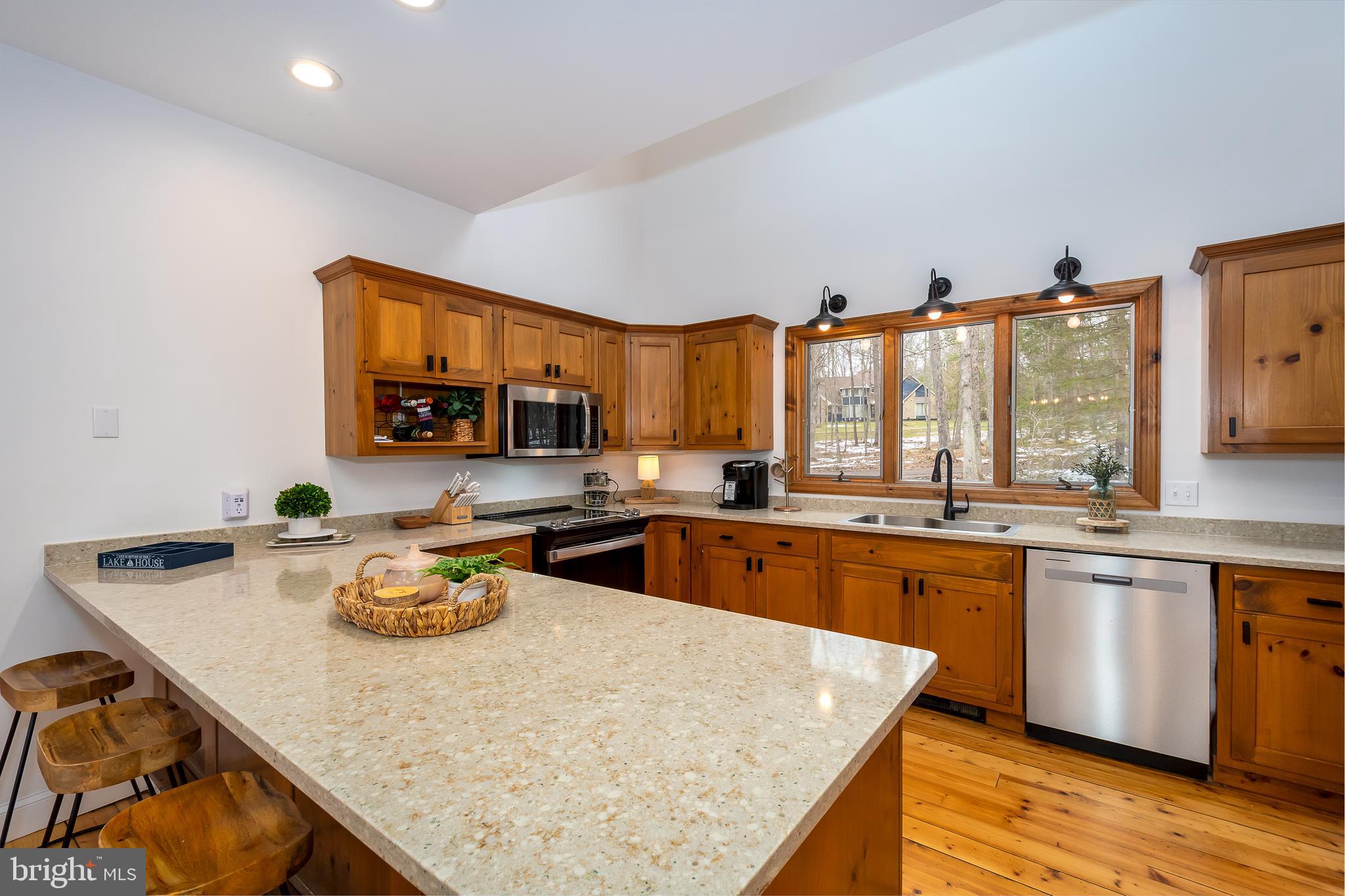 1038 South Blakeslee Road Oakland, MD 21550 - Photo 14 of 69 a kitchen with stainless steel appliances granite countertop a table chairs in it and wooden floors