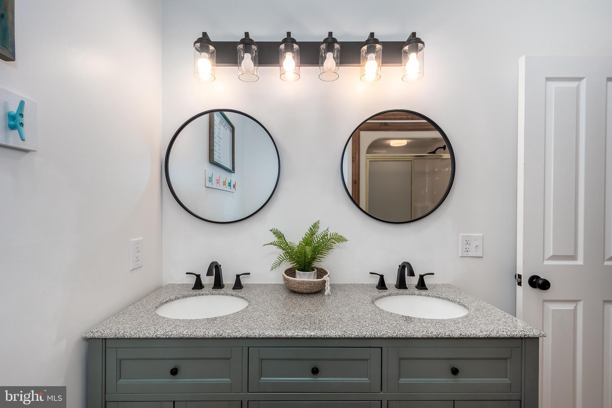 1038 South Blakeslee Road Oakland, MD 21550 - Photo 25 of 69 a bathroom with a granite countertop double vanity sinks and a mirror