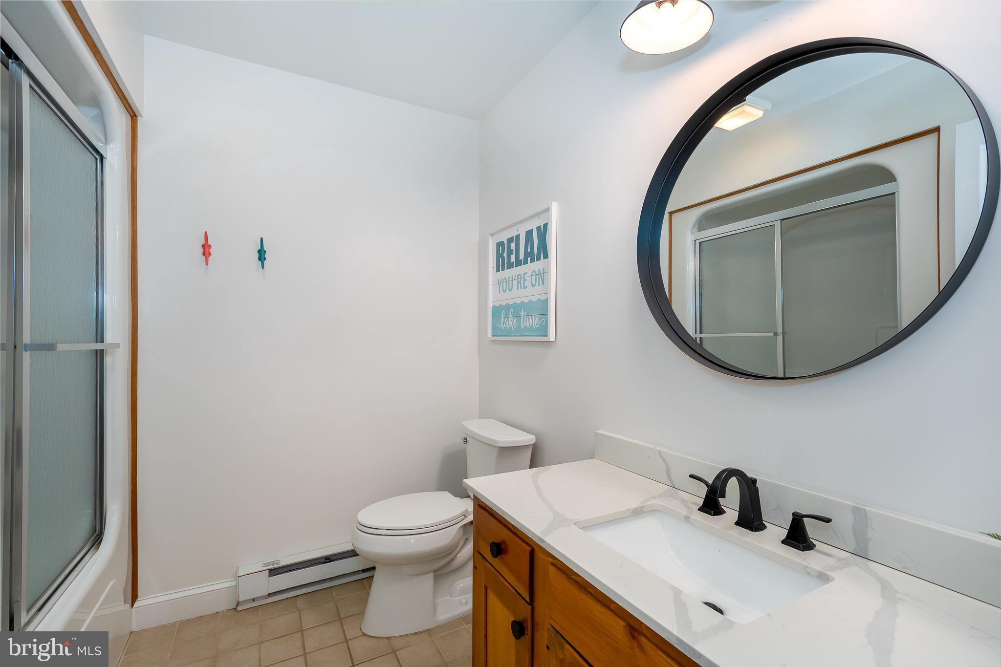 1038 South Blakeslee Road Oakland, MD 21550 - Photo 52 of 69 a bathroom with a sink a toilet and a mirror