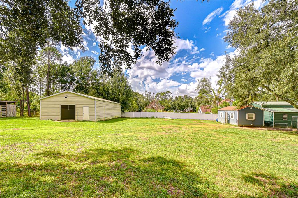 16349 Spring Valley Road Dade City, FL 33523 - Photo 12 of 40 a big house with a big yard and large trees