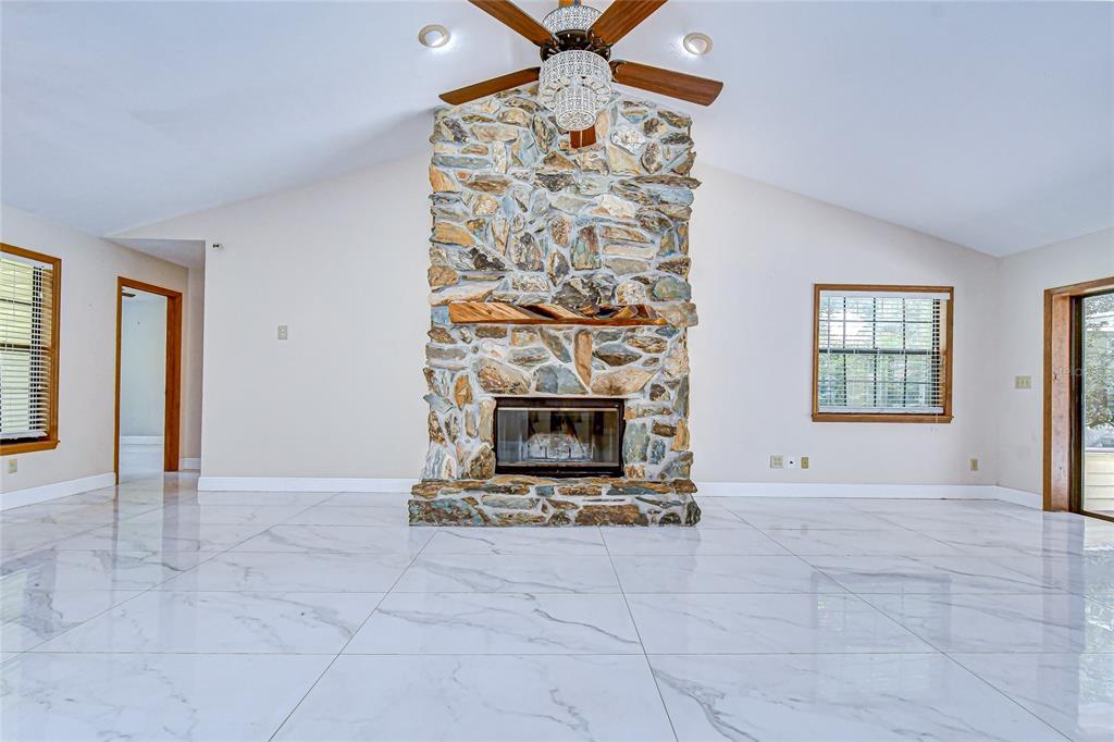 16349 Spring Valley Road Dade City, FL 33523 - Photo 16 of 40 an empty room with windows and fireplace